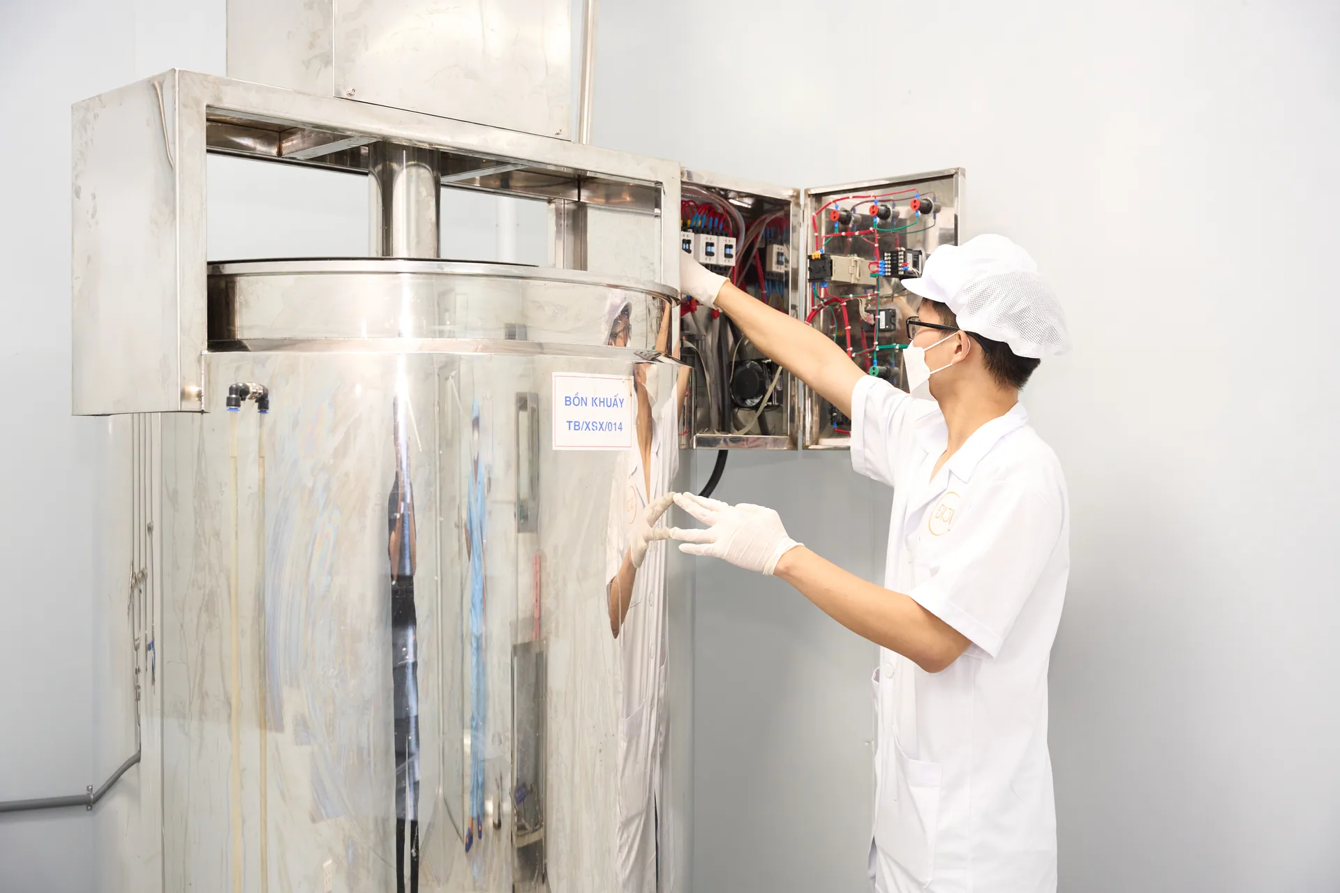 Kỹ thuật viên kiểm tra tủ điện của bồn khuấy trong khu sản xuất