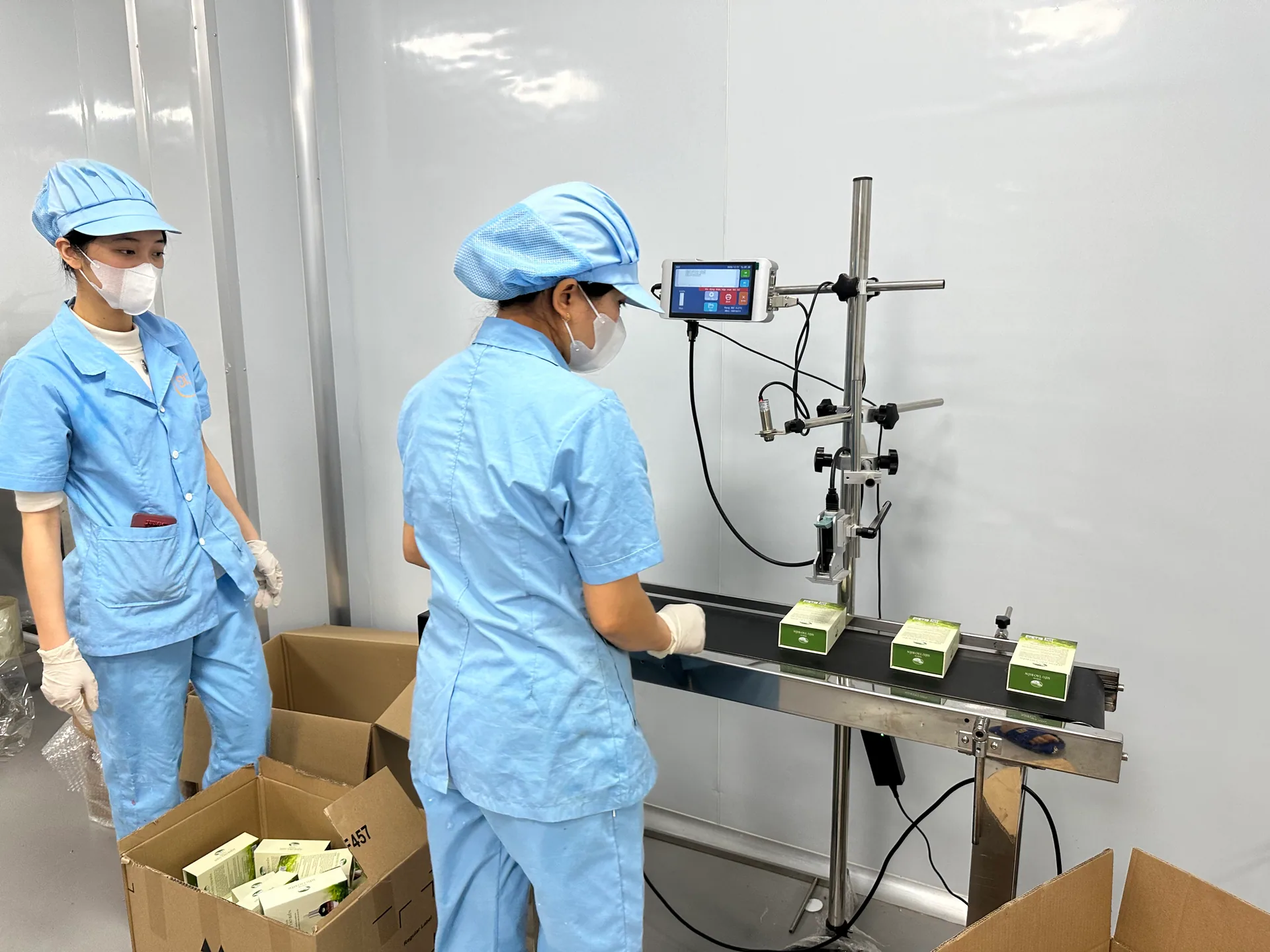 Công nhân vận hành máy in hạn sử dụng lên vỏ hộp sản phẩm