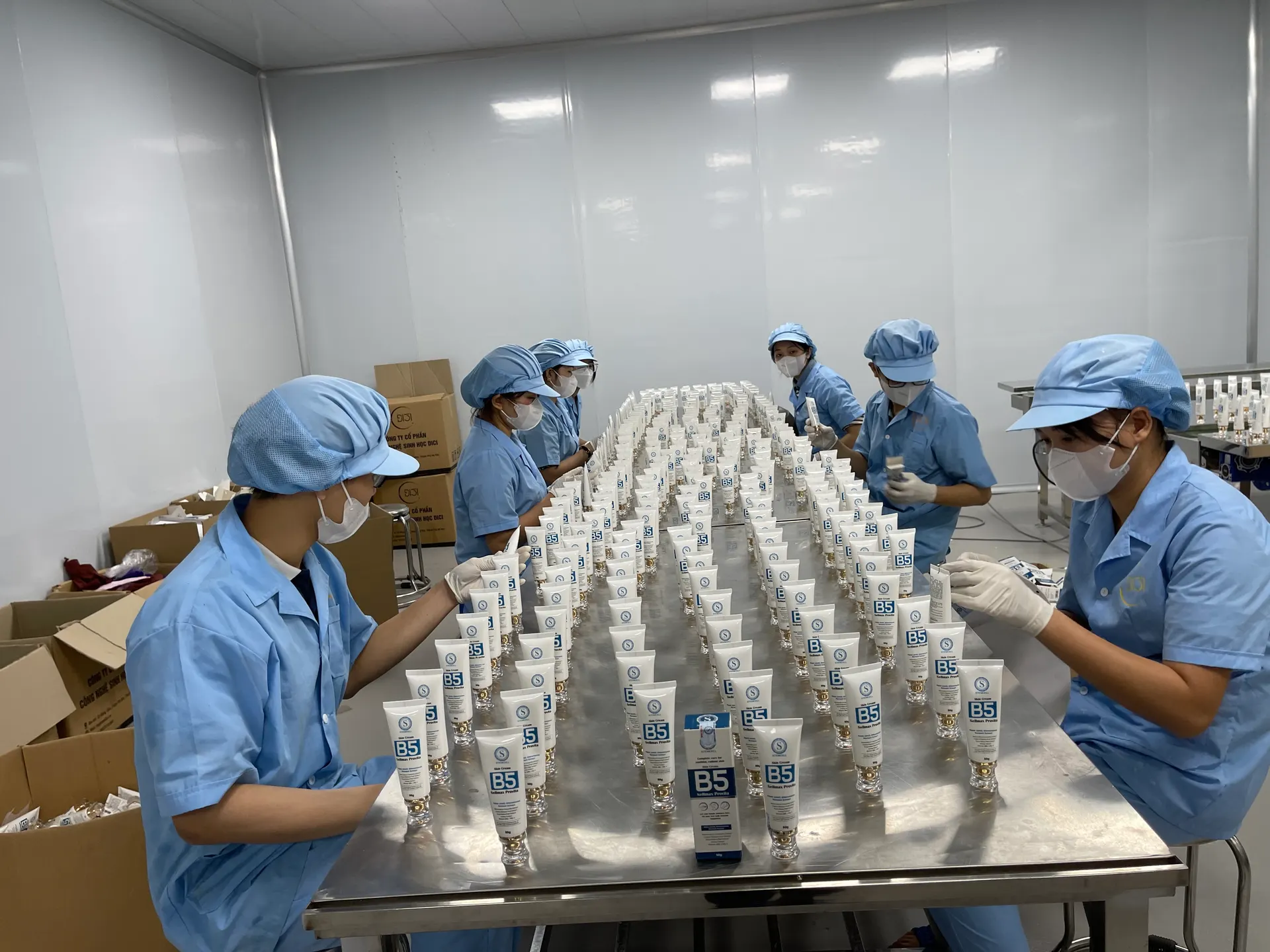 Công nhân xếp tuýp sản phẩm thành hàng trên bàn hoàn thiện